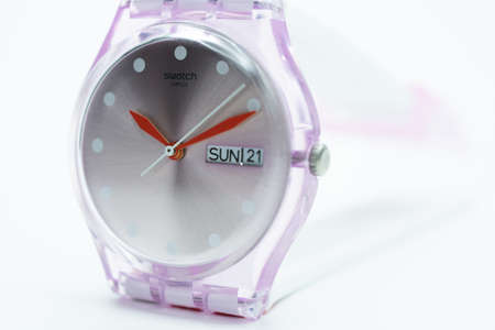 New York, NY, USA 07.10.2020 - Swatch swiss made quartz watch isolated on white background close up. transparent plastic case. Red arrows design. Swatch Group watch production. SUN 21 on calenderのeditorial素材