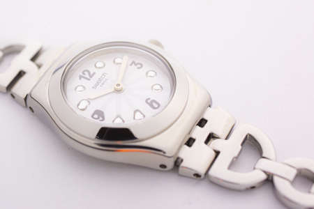 London, GB 07.10.2020 - Swatch classic design swiss made mechanical watch close up isolated on white. metal case, stylish trendy womens accessory with rhinestones. Swatch Group watch productionのeditorial素材