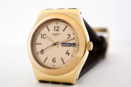 Rome, Italy 07.10.2020 - Swatch fashion swiss made quartz watch selective focus close up. stylish trendy womens accessory. young businesswoman fashion detail. Monday 24 day and date. Gold PVDのeditorial素材