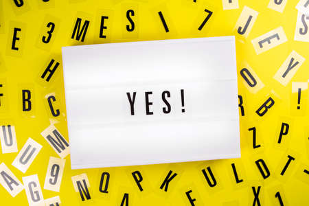 Yes! word on lightbox on scattered letters background of plastic alphabet. Election victory, electoral success, economic recovery from global crisis, Sport Win conceptの写真素材