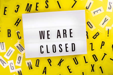 We Are Closed message on lightbox on scattered letters background of plastic alphabet Global economic crisis, quarantine due to , shutdown of restaurants and entertainment facilities conceptの写真素材