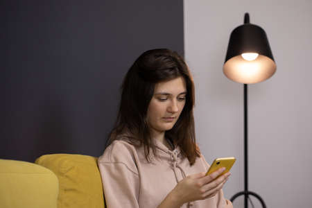 Attractive long-haired brunette girl Chatting and texting on smartphoneの写真素材