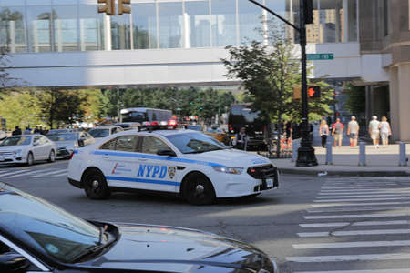 New York City, NY, USA 2.09.2020 - NYPD car at intersection of South End Avenue and Liberty Street downtown of Manhattan at summer day. police car with flashing lights rushes. serve and protectのeditorial素材