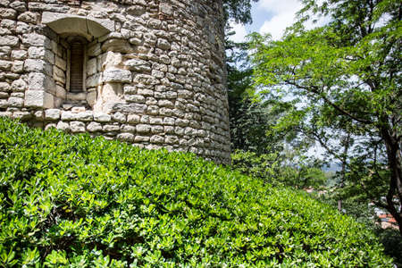 Girona, Spain, May 1, 2020 - medieval tower made of stone and covered with green vegetationのeditorial素材