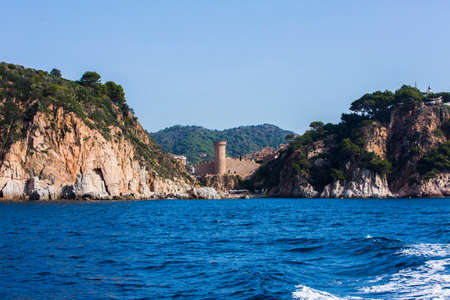Tossa de Mar, Spain, May 1, 2020 - view from sea of ancient fortress in Tossa de mar on Costa Brava rocky coast. Welcome to Catalonia concept copy space. Most Picturesque Viewsのeditorial素材