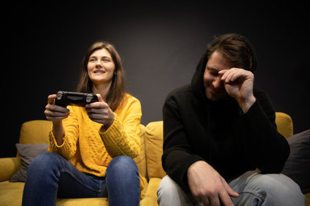 Attractive young couple having fun playing video games console joysticksの写真素材