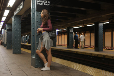 New York City, NY, USA 2.09.2020 - Pretty long hair tourist girl waiting for Train at Whitehall Street, South Ferry Subway Station in Manhattan. NYC Transit Authority subway system has 469 stationsのeditorial素材