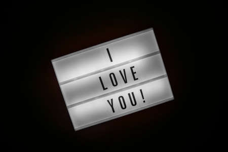 Lightbox with message I LOVE YOU isolated on black background. Inscription glows in dark. Concept of warmth feeling, declaration of sympathy, affection, tenderness, care, St. Valentines Dayの写真素材