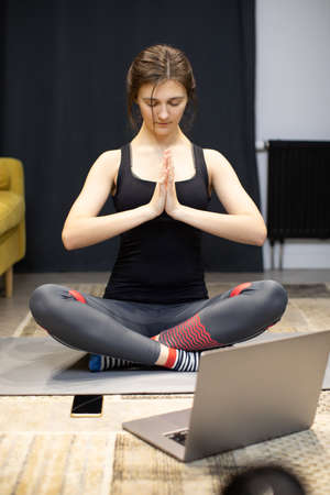 yogi woman practicing yoga at home sitting closed eyes in Sukhasana exerciseの写真素材