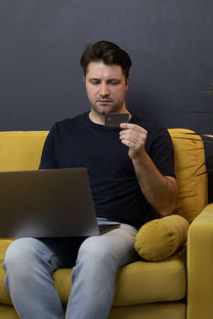 guy makes purchases or payments online, looks at credit card cvv security codeの写真素材