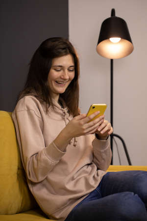 Attractive long-haired brunette girl Chatting and texting on smartphoneの写真素材
