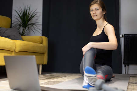 young healthy body fit woman training at home, making gym exercise on sport matの写真素材