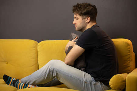 Depressed unshaven guy suffering from depression on sofa. mental illness, stressの写真素材