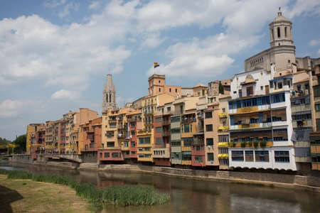 Girona, Spain, May 1, 2020 - LGBT flag over buildings along Onyar river. Girona Cathedral and residential houses. social equality of LGBT community and people conceptのeditorial素材