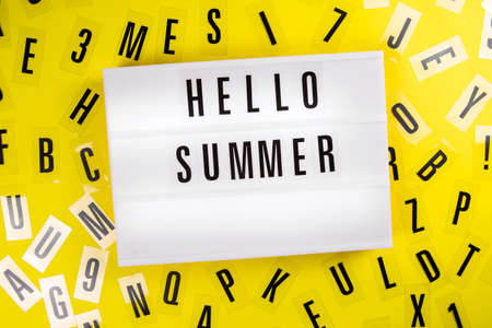 Lightbox with text HELLO SUMMER on yellow background with black letters randomly scattered. Concept of summertime, hot travel season, vacation, holiday, event ad, offer, sale, discount, promotionの写真素材