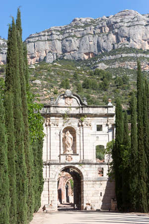 Tarragona, Spain, May 1, 2020 - Facade Ruins of monastery Cartoixa Escaladei in Catalonia on background of mountains and alley of thuja. Catalan History of Middle Ages. UNESCO heritageのeditorial素材
