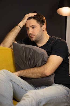 Depressed unshaven guy suffering from depression hugging pillow, mental illnessの写真素材