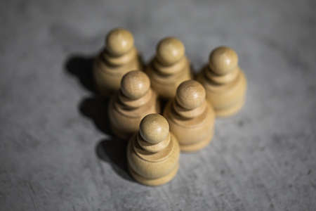 triangle made up of tightly shifted chess pieces of six pawns. Teamwork, close-knit teams, horizontal social ties. Armies ready for battle, troops lined up for fight, three-way split arrowの写真素材