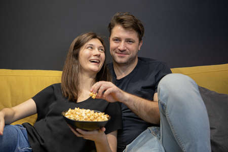 Couple watch Funny tv movie laughing lying on soft couchの写真素材