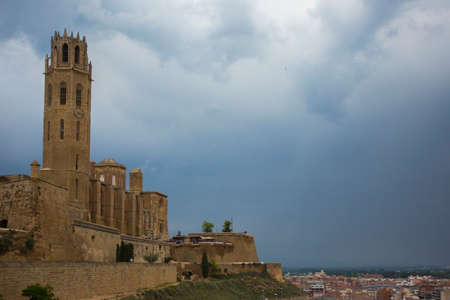 Lleida, Spain, May 1, 2020 - tower and fortress wall of La Seu Vella former Roman Catholic cathedral church under thunderclouds. Symbol of Reconquista, historical struggle between Moors and Christiansのeditorial素材