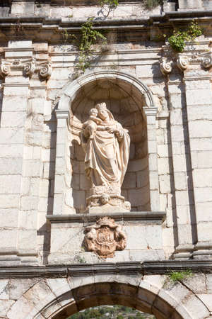 Tarragona, Spain, May 1, 2020 - Statue of Virgin Mary with baby Jesus on facade of old monastery Cartoixa Escaladei in Catalonia. History of Religion and Monasticism in Medieval Cataloniaのeditorial素材