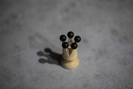 white queen wooden chess piece casts shadow on gray table copy space. single figurine, lonely queen without entourage. minimalist design, concept of solitudeの写真素材