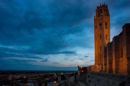 Lleida, Spain, May 1, 2020 - illuminated tower and fortress wall of La Seu Vella former Roman Catholic cathedral church at night on hill above city. Welcome to Catalonia touristic Concept Copy spaceのeditorial素材