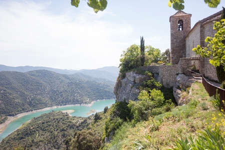 Siurana, Tarragona, Spain, May 1, 2020 - Romanesque church of Santa Maria de Siurana. most photogenic place. Welcome to Catalonia concept copy space. siurana reservoir on backdrope. UNESCO heritage.のeditorial素材