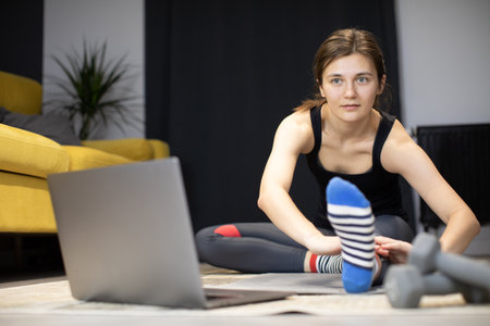 young healthy body fit woman training at home, making gym exercise on sport matの写真素材