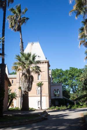 Cambrils, Spain, May 1, 2020 - Castle in Botanical Garden Park Sama. Beautiful Park Landscape and palm trees under blue skyのeditorial素材