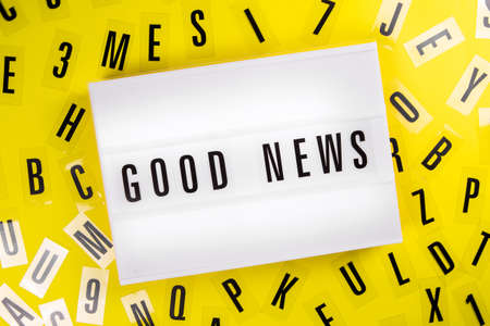 Lightbox with message GOOD NEWS on yellow background with black letters randomly scattered. Concept of positive happy news, information about success victory achievement, ad, sale, promotionsの写真素材