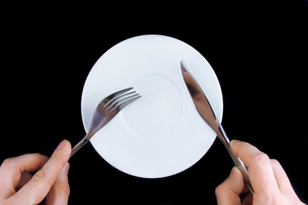 Table serving-knife, fork in hands on colour background.の写真素材