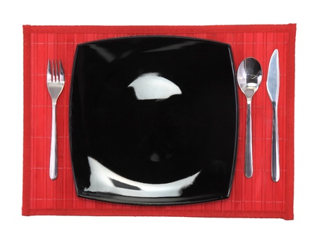 Table serving-knife,plate,fork on  red colour background.の写真素材
