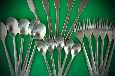 Collage of flatware on green background.の写真素材