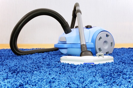 Powerful vacuum cleaner stand  on blue carpet.の写真素材