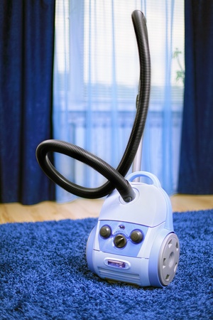 Powerful vacuum cleaner stand  on blue carpet.の写真素材