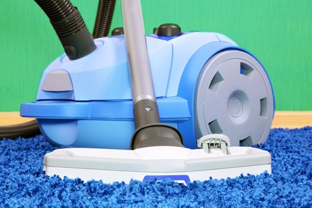 Powerful vacuum cleaner stand  on blue carpet.の写真素材