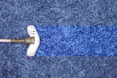 The metal pipe of vacuum cleaner in action - clean stripe on the carpet.の写真素材