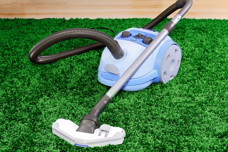 Vacuum cleaner stand  on green  carpetの写真素材