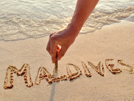 Inscription "Maldives" in the sand on a tropical island,  Maldives.の写真素材