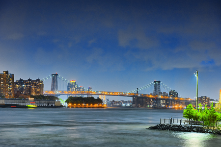 New York night view of the Lower Manhattan and the Manhattan Bridge across the East River. USA.