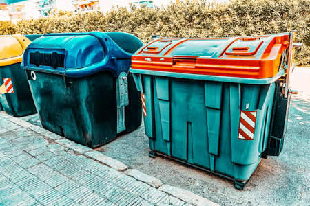 Variety dumpsters(recycling containers ) on a city streetの写真素材