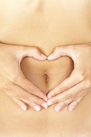 Hand on belly isolated on whiteの写真素材