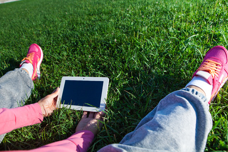 table pc in a hand for a girl on a background a green grassの写真素材