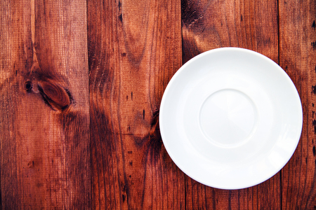 white plate on the wooden brown tableの写真素材
