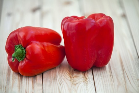 Colored bell peppers on wooden tableの写真素材