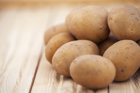 Raw potatoes on a wood tableの写真素材