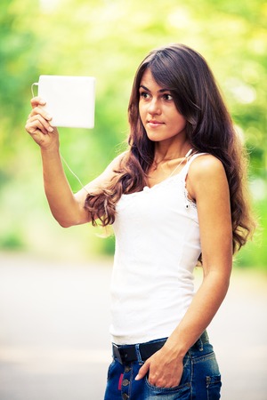 a girl sits on a bench and reads a bookの写真素材