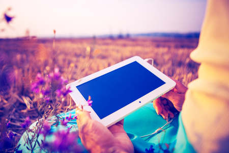 a woman in the field sits on earth with a plane-table in handsの写真素材