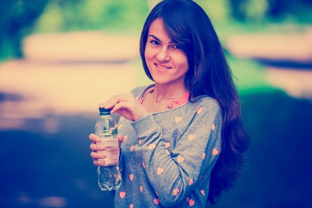 a girl drinks water after sportの写真素材